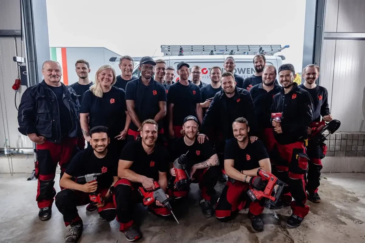 Team der PV Energy Group mit Werkzeugen vor dem Firmenfahrzeug in der Werkstatt